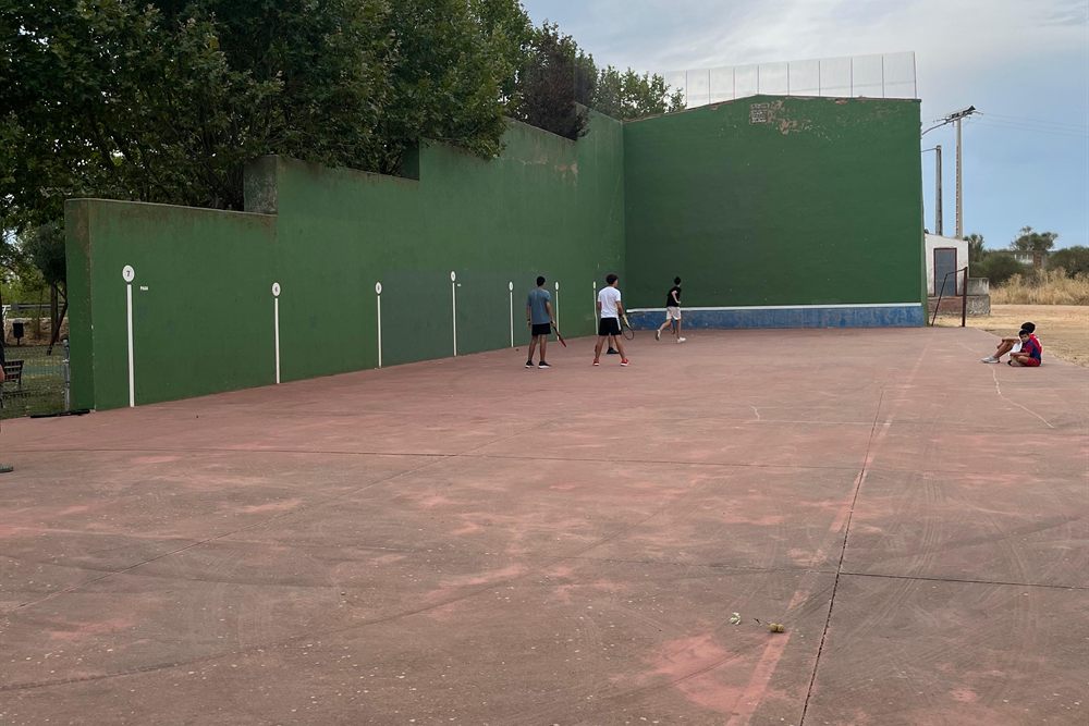 Frontón del pueblo, con el muro verde y la cancha de hormigón.