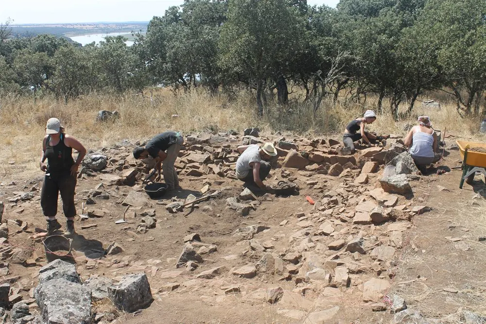 Arqueólogos trabajando en una campaña de excavación en El Castillón, con las estructuras de piedra a la vista