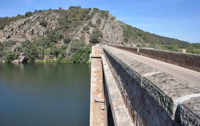 El río Esla embalsado en Ricobayo a su paso por Puente Quintos, con un cerro rocoso cubierto de encinas