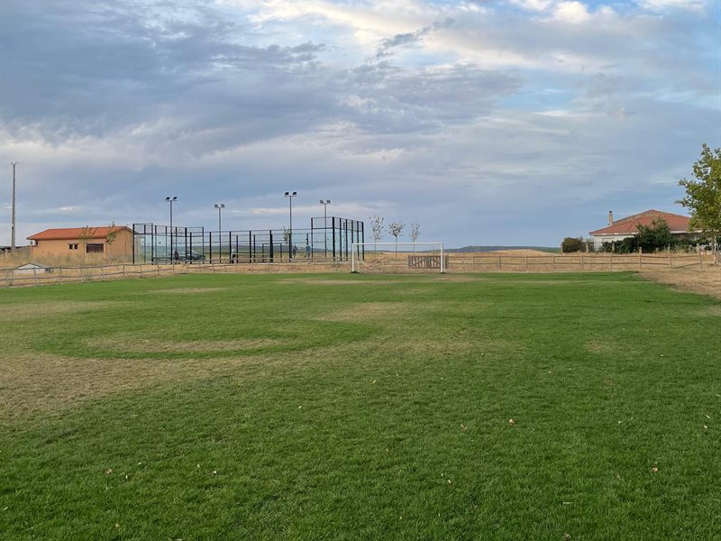 Campo de fútbol de hierba de Moreruela de Tábara, con la pista de pádel y el campo abierto al fondo.